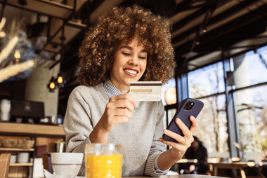 Woman using a credit card and smartphone while reviewing spending and credit card debt